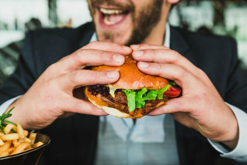 lykkelig mann spiser burger. foto