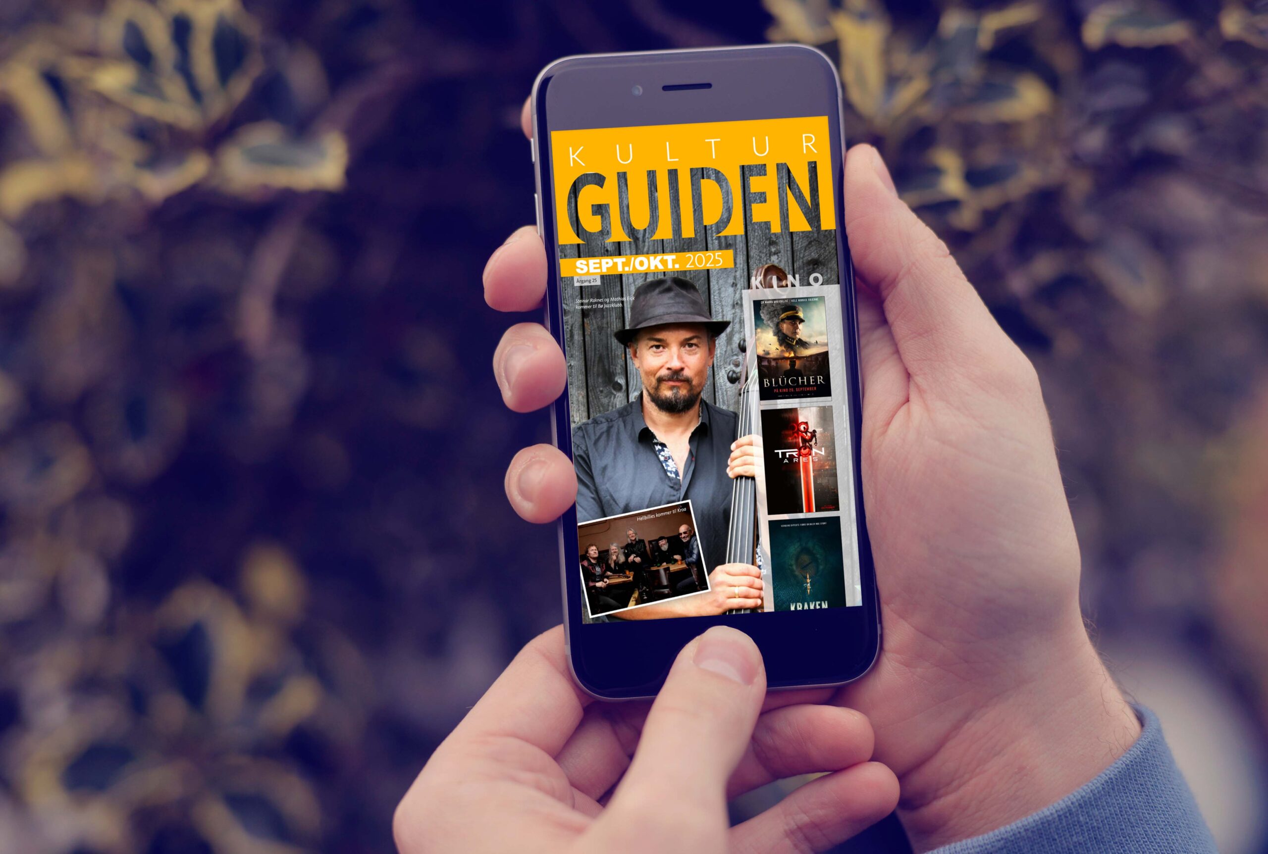 Hånd holder mobil med KulturGuiden september/oktober 2025.