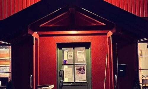 Inngangen til Gvarv Bakeri med rød fasade og lanterner, perfekt for koselige bakermomenter.